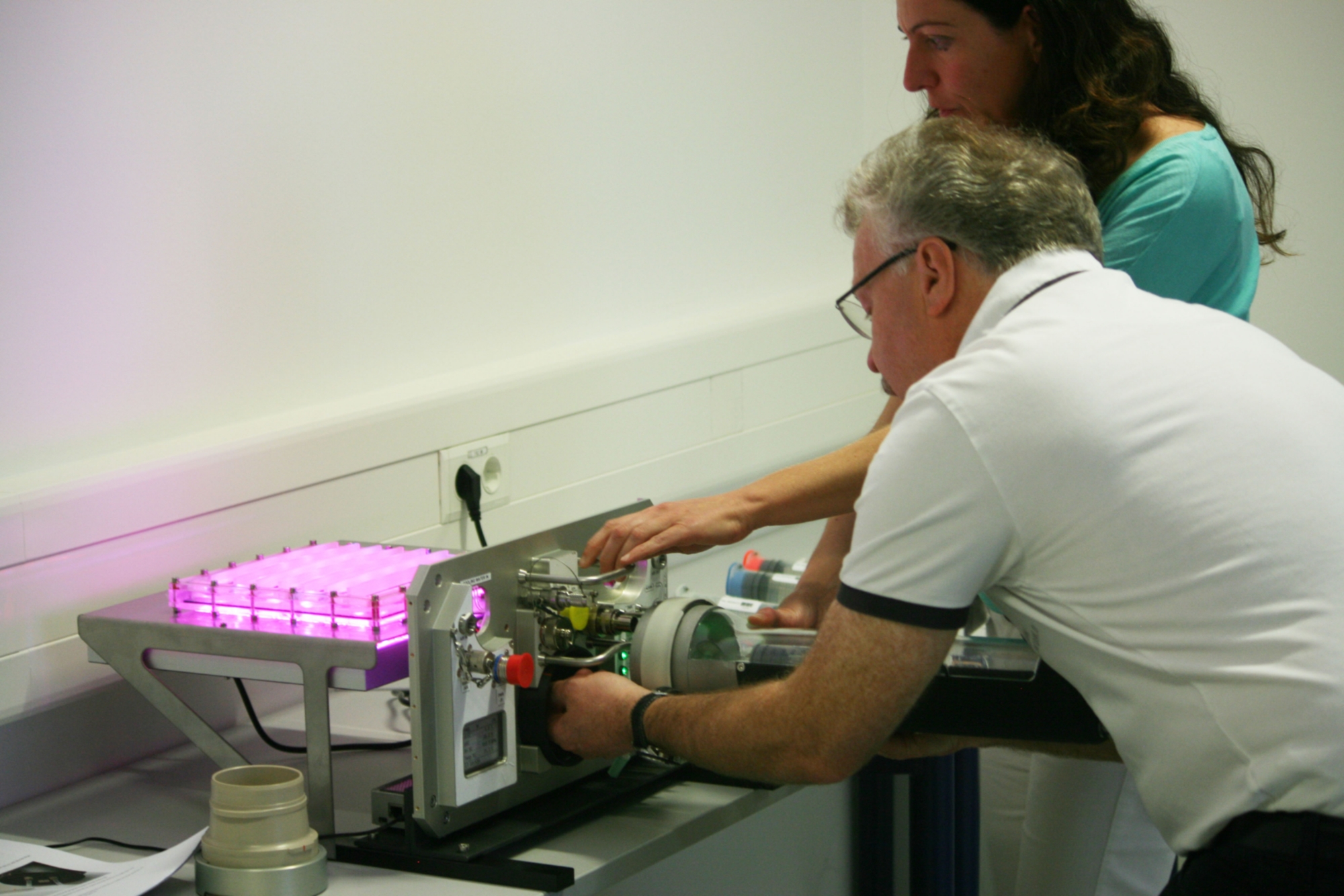 Herr Professor Ewald verbindet das „Liquid Exchange Device“, unter der Anweisung von Frau Dr. Serena Bertone, mit dem Photobioreaktor.